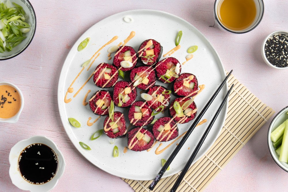 Sushi met rode bietenrijst, zalm, komkommer en avocado