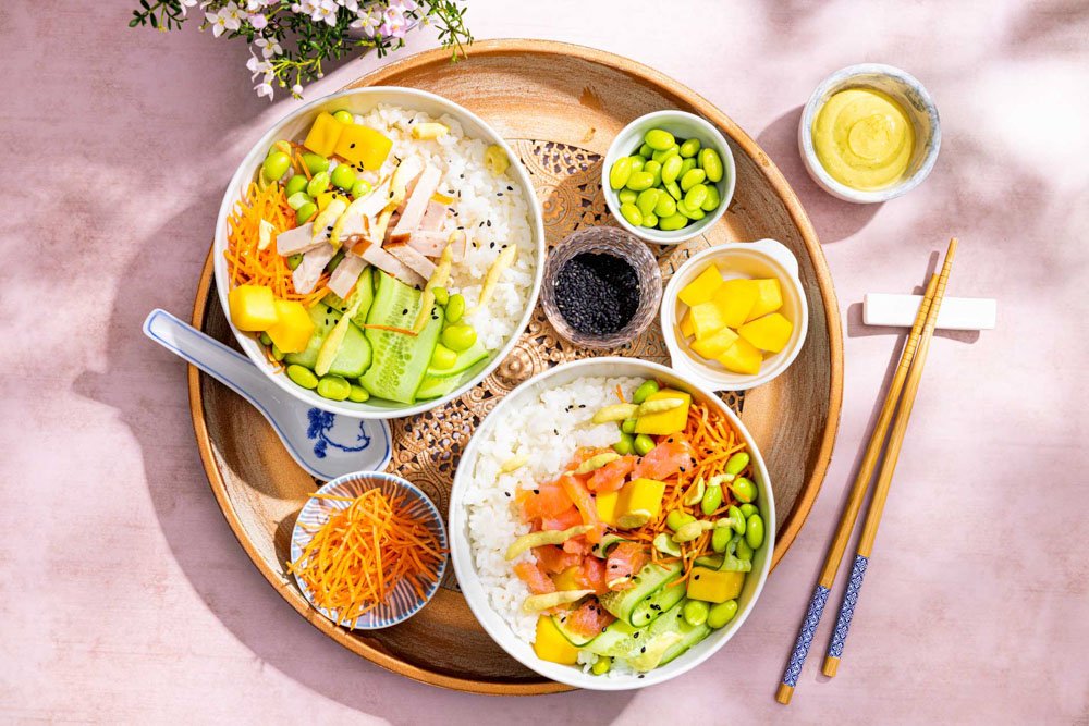 Poké bowl met sushi rijst, groenten en kip of vis